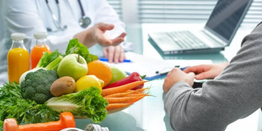 doctor speaking with patient with a pile of food on the table between them