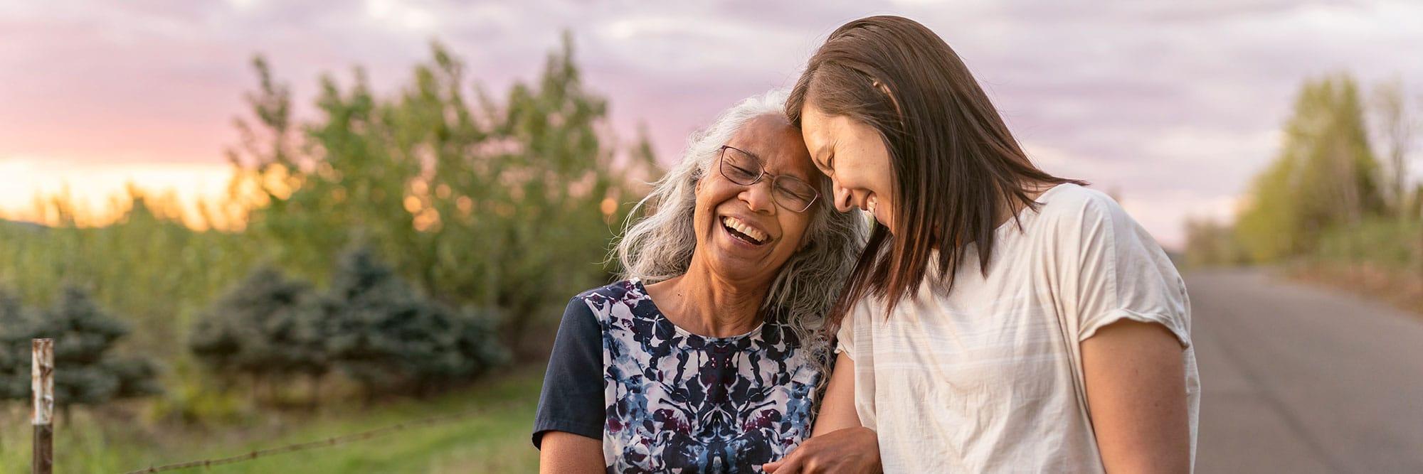 An older woman with a younger woman enjoying a relaxing stroll outside