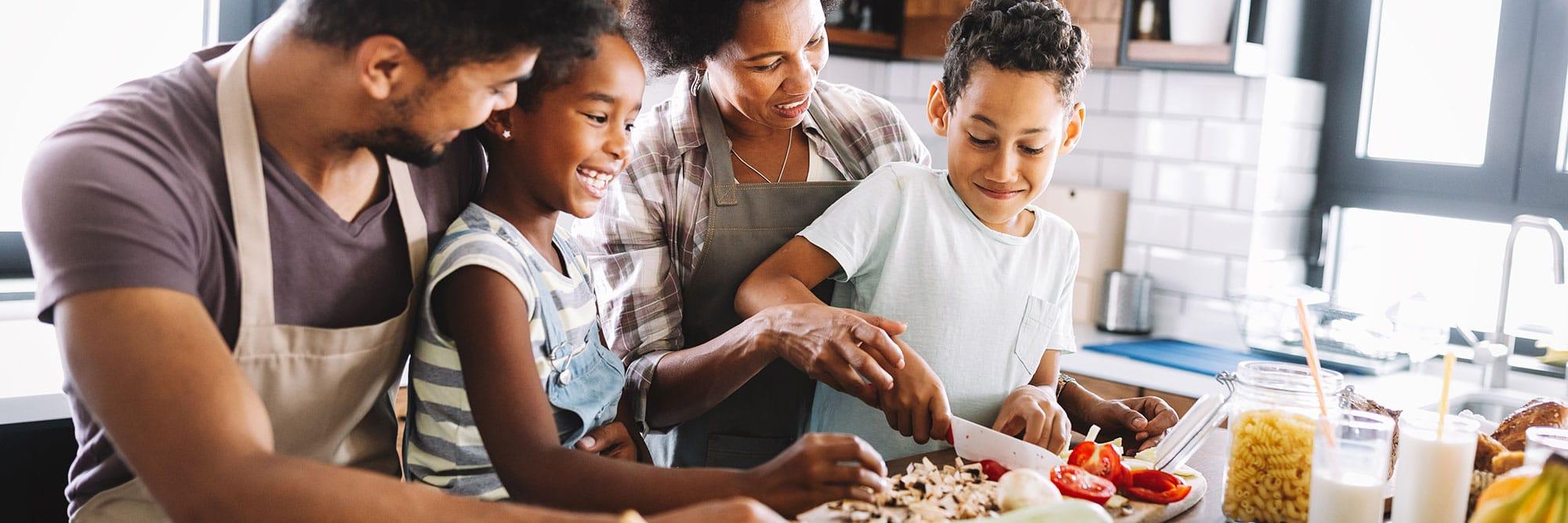 Family cutting vegetables together