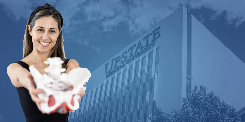 Dr. Rebecca Alexander Carey pictured in front of the New Academic Building holding pelvic bones