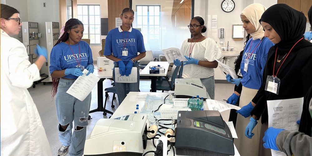 Magenta Love. MS, MLS(ASCP) SCYM, clinical assistant professor of Clinical Lab Science, guides students through urinalysis lab.