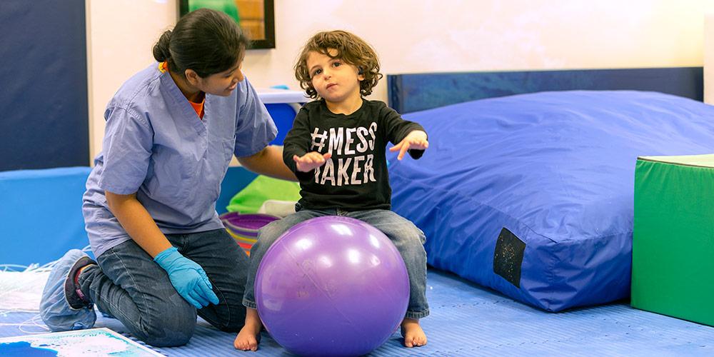 Nurse with child on bounce ball