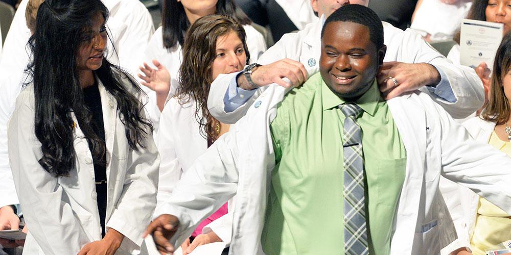 Student receiving his white coat