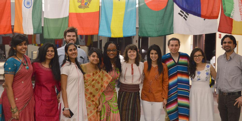 More international students pose in front of international flags