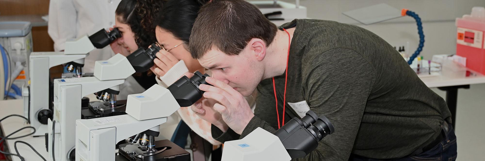 Students exploring specimens under microscopes