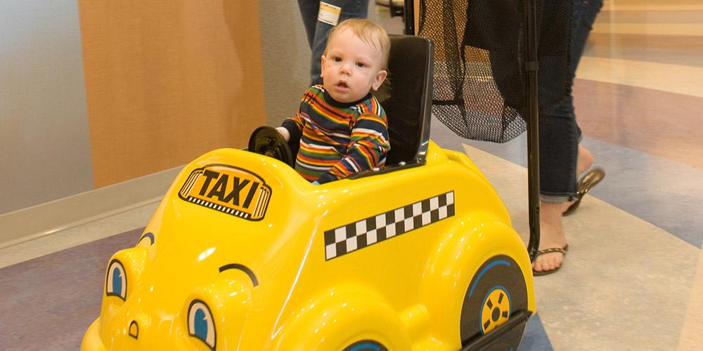 young patient in toy car