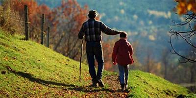 Man and child walking into the sunset