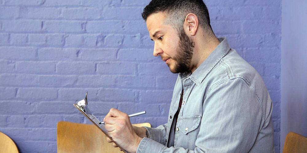 Making notes on a clipboard.