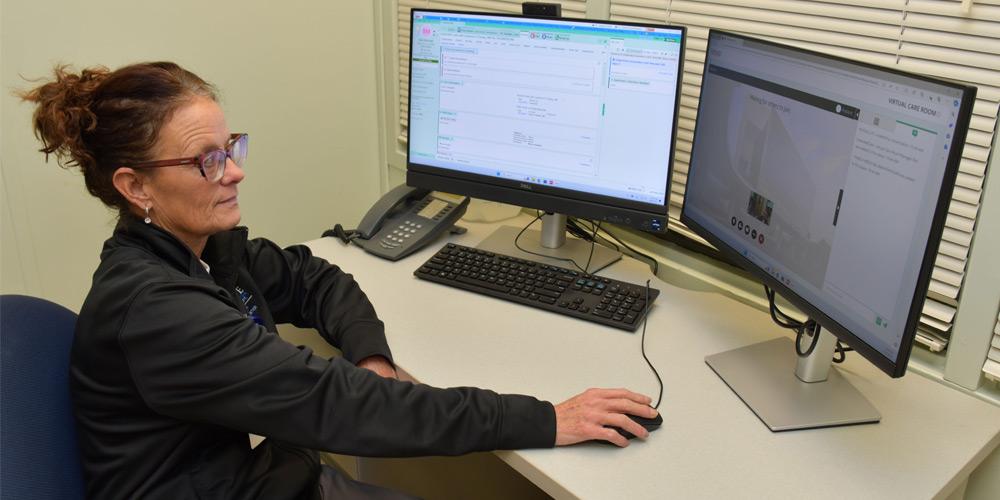 Nurse Jackie sits at computer waiting for patient to join virtual care room