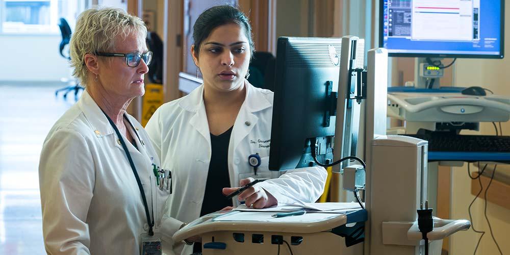 white coats looking at computer