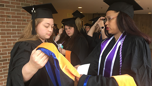Students in the College of Nursing go over the last-minute details about academic garb, before the college's Commencement ceremonies.