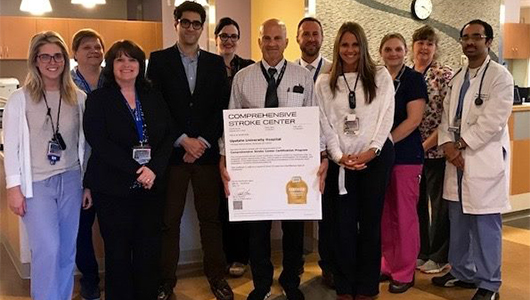 Interim CEO of Upstate University Hospital Robert Corona, DO, MBA, is joined by members of the Comprehensive Stroke Center team to present the certificate recertifying Upstate as a Comprehensive Stroke Center.