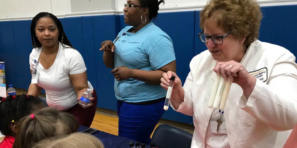 Susan Graham, MS, MT (ASCP), SH, chair and program director in the Department of Clinical Laboratory Science and associate dean in the College of Health Professions, educates students about fat at a STEAM night in the Syracuse City School District.