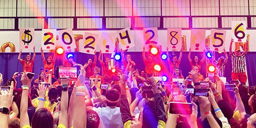 OttoTHON dancers hold up signs with the total amount raised this year, which was $202,428.56.