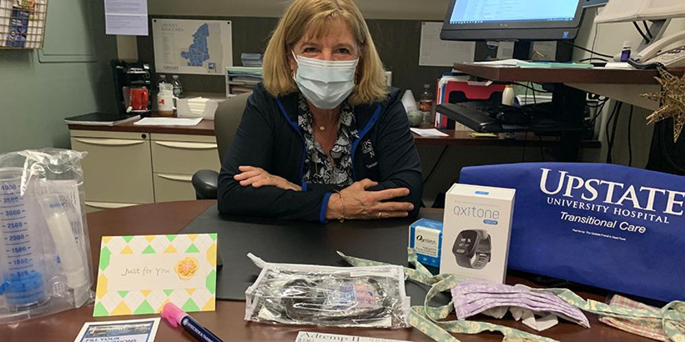Diane Nanno sits with an Upstate Comfort Care Kit.