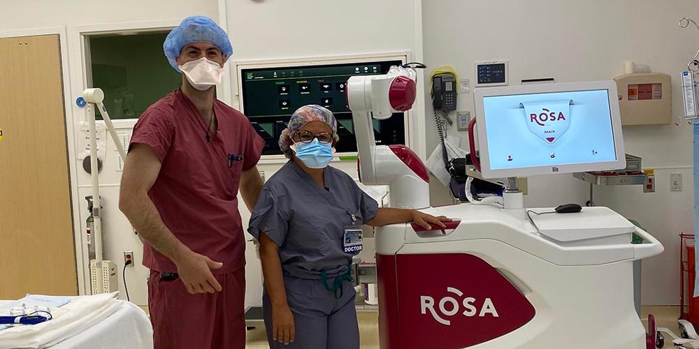 Two Upstate doctors stand in the operating room with the new ROSA Brain robot.