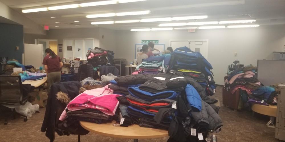 COLLECTING COATS: New winter coats get sorted by Upstate students for delivery to STEM Dr. King Elementary School in Syracuse. Upstate students responded to a call for winter wear from school officials, and in response, students organized a coat drive and collected more than 450 winter coats from employees and students from all across the Upstate campus.