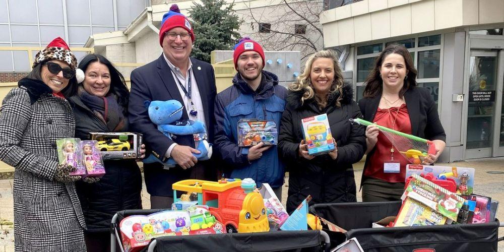 GIFT GIVERS: Staff from the Upstate Foundation and Upstate Golisano Children’s Hospital receive toys gathered from Galaxy Media and Onondaga Lake Park’s Lights on the Lake Run. These toys will help children and their families who are in the hospital during the holiday season.