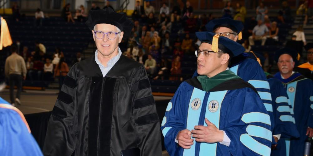 COMMENCEMENT VIP: Upstate honorary degree recipient and Commencement speaker Patrick O. Brown, MD, PhD, takes part in the faculty procession with Norton College of Medicine Dean Lawrence Chin, MD, during Commencement May 7. Brown is chief visionary officer of Impossible Foods, Inc., founder and president of the Impossible Foundation and professor emeritus at Stanford University.