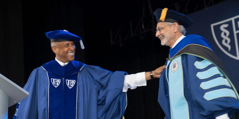 COMMENCEMENT SPEAKER: Upstate Medical University President Dr Mantosh Dewan, who also is a SUNY Distinguished Service Professor, is introduced by SUNY Downstate President Dr. Wayne J Riley during SUNY Downstate’s Commencement May 11. Dewan was the Commencement speaker and also received the 2023 SUNY Downstate’s President’s Award.