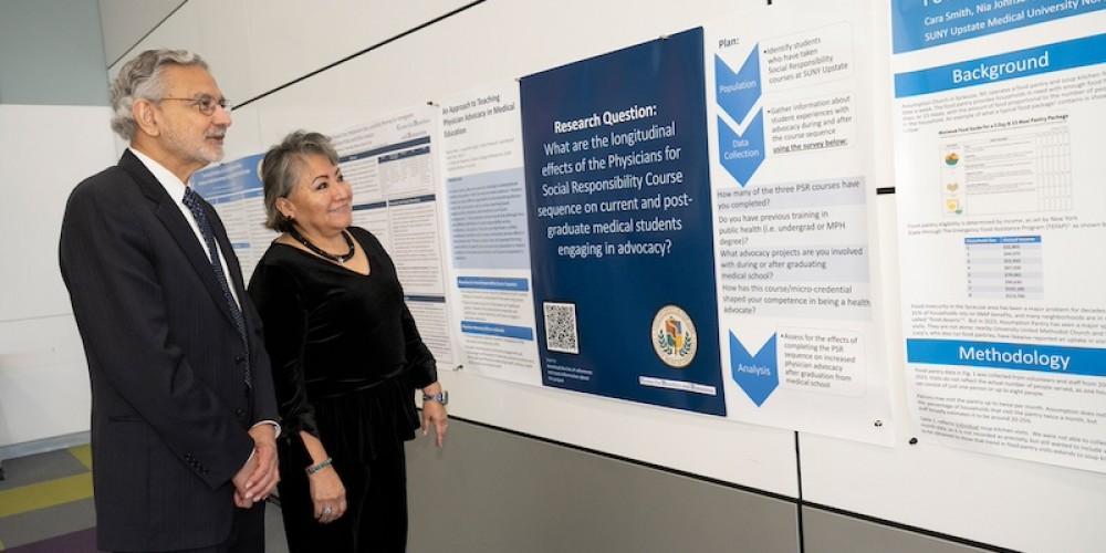  VIP VISIT:  Roselyn Tso, director of U.S. Indian Health Services, and Upstate President Mantosh Dewan, MD, review research posters by faculty and students at Upstate’s Health Justice Conference, held annually on Martin Luther King Day. Tso delivered the keynote address. Tso administers a nationwide health care delivery program responsible for providing preventive, curative, and community health care to approximately 2.7 million American Indians and Alaska Natives.