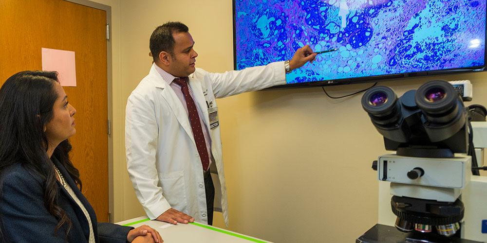 Dr. Mehta in the Biopsy Lab with microscope and TV.