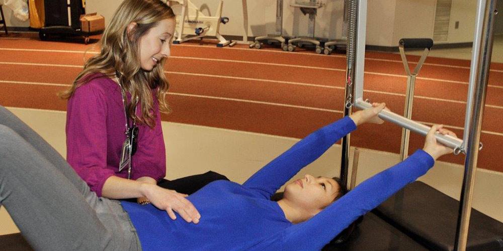 physical therapist doing pilates with patient