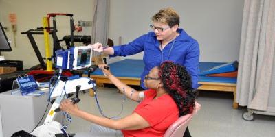 therapist assisting patient with use of state of the art bicycle