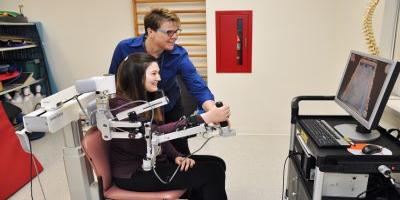 Patient and therapist using Armeo equipment for recovery of upper extremity