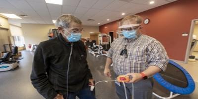 Physical therapist monitoring the vitals of a post covid patient.