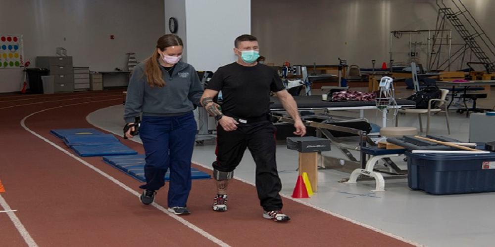 Therapist walking with a patient using the bioness device