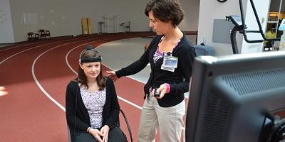 Therapist with seated patient about to use the Neurocom device