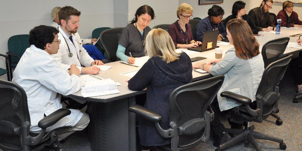 Doctors, occupational therapists, physical therapists, speech therapists, recreational therapists, rehab counselors, and other medical professionals in rehabilitation medicine are sitting around a table.