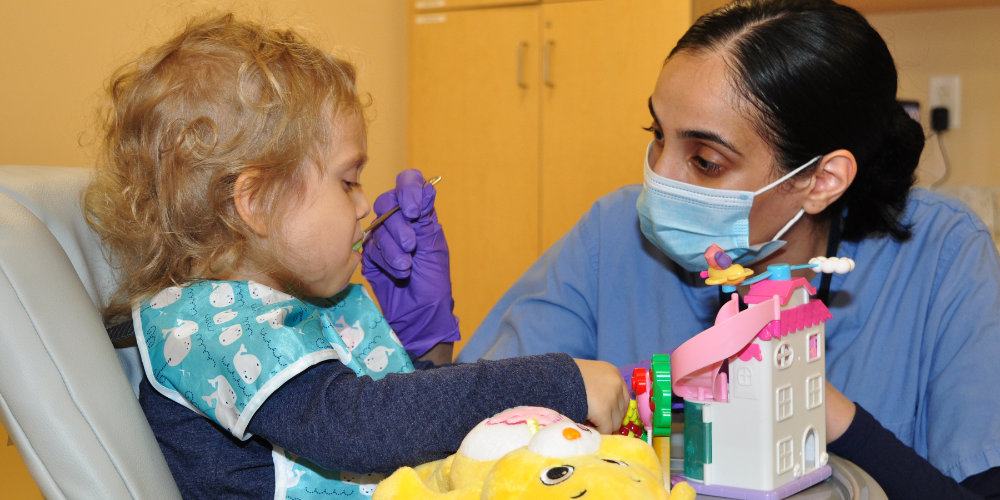 Upstate worker assisting the feeding of a child