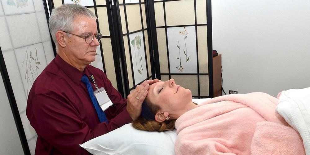 Bob Crandall performing reiki on a patient