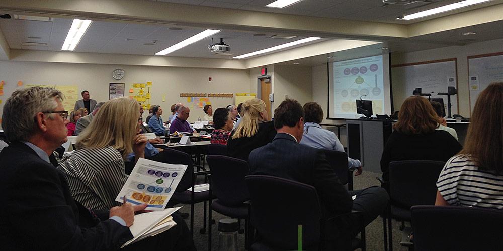 Dr. Laraque-Arena, President, and participants in the Balanced Scorecard strategic planning process receive an update on the work of the Theme Teams.