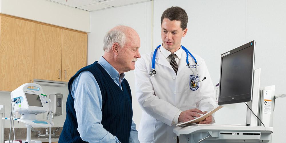 Dr. Maclaughlin with patient in his office.