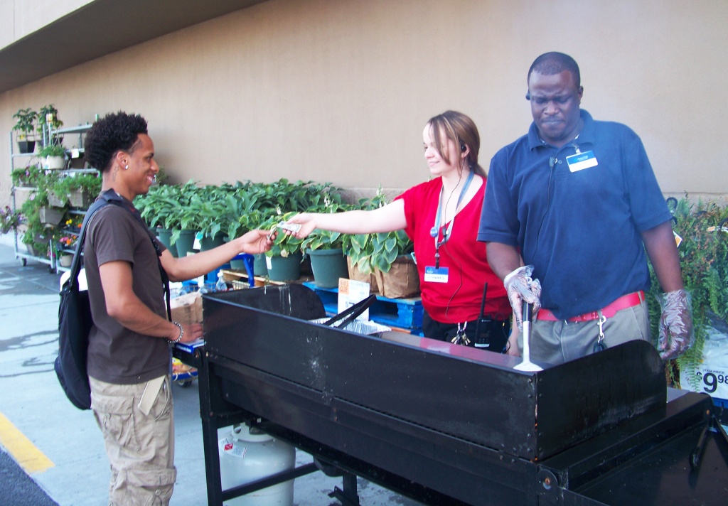 Sam‘s Club employees cooking hamburgers and hot dogs to raise money for the Upstate Golisano Children‘s Hospital