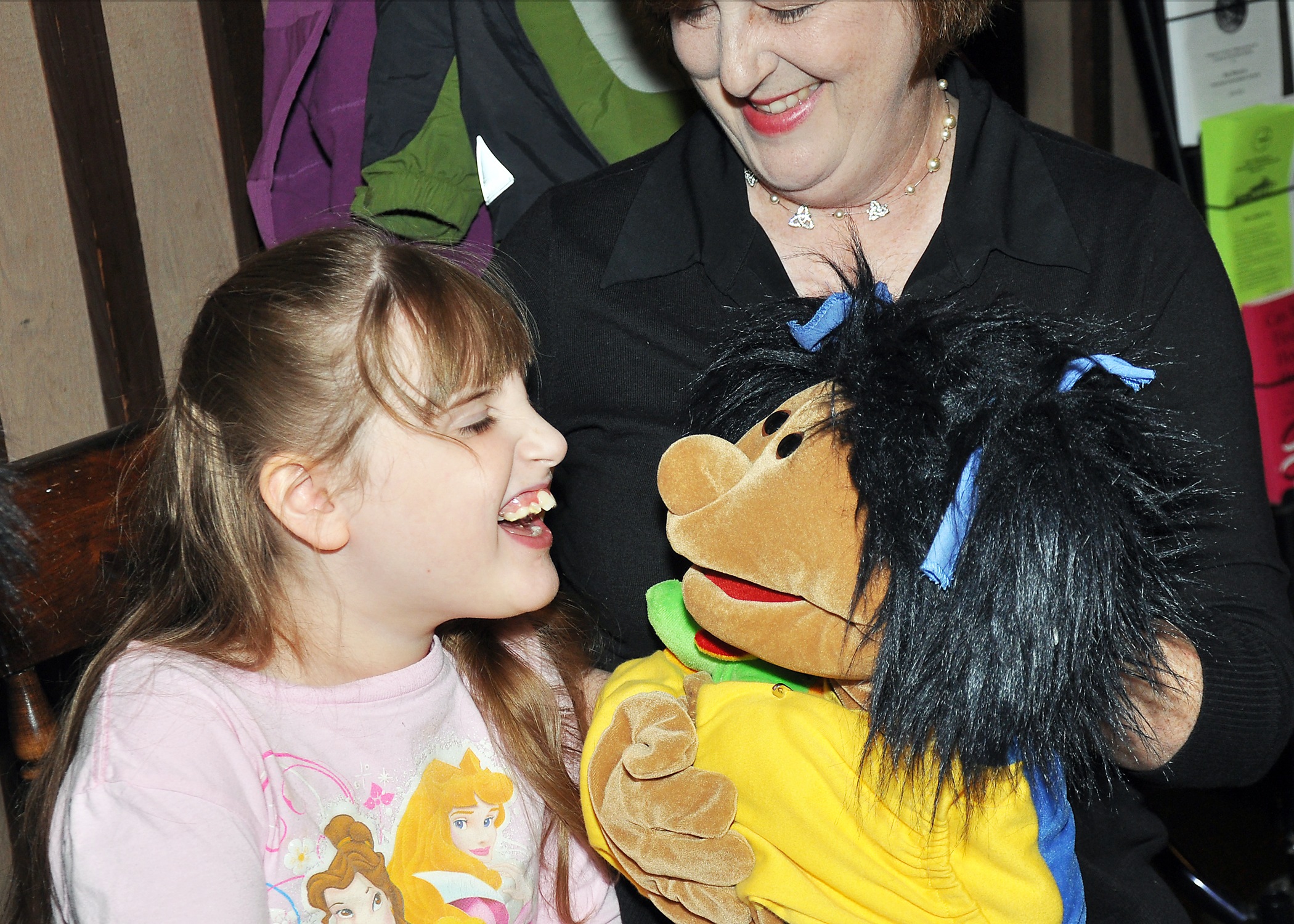 DSC_0291 Alexandria, 8, of Chittenango laughs with Sally, a puppet with autism. In the back is puppeteer Terry Kiritsis, who is a special educator at the Margaret Williams Center.