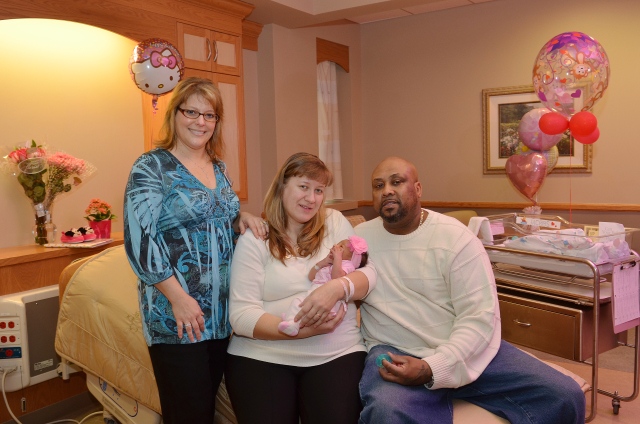 Certified nurse midwife Heather Shannon with new parents, and James Jacobs and their daughter.