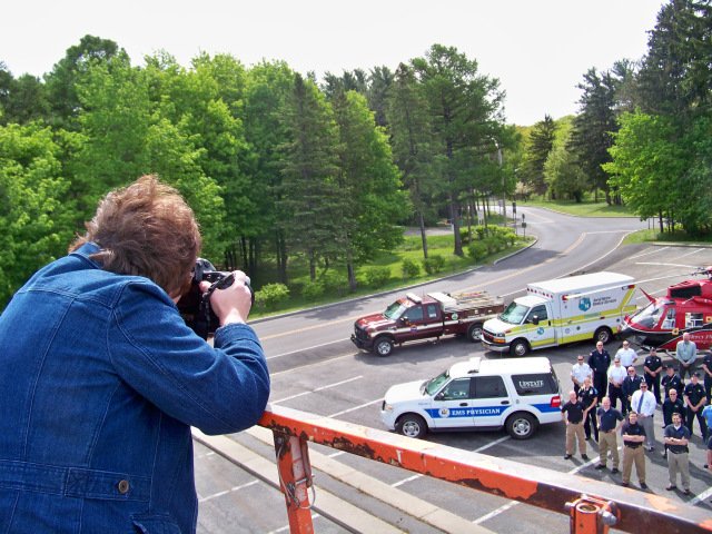 Photographer Susan Kahn takes a group photograph of emergency responders and physicians in the parking lot at Upstate University Hospital's Community Campus