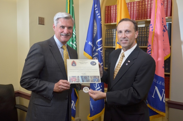 Upstate President, Dr. David Smith, MD accepts the medallion and certificate from NASA flight surgeon Dr. Joseph Dervay, MD, a 1984 graduate of Upstate Medical Center. Photo by William Mueller.