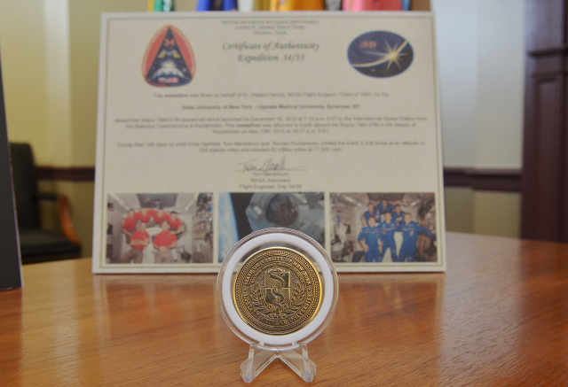 The medallion that spent time in space, in front of the certificate of authenticity. Photo by William Mueller.