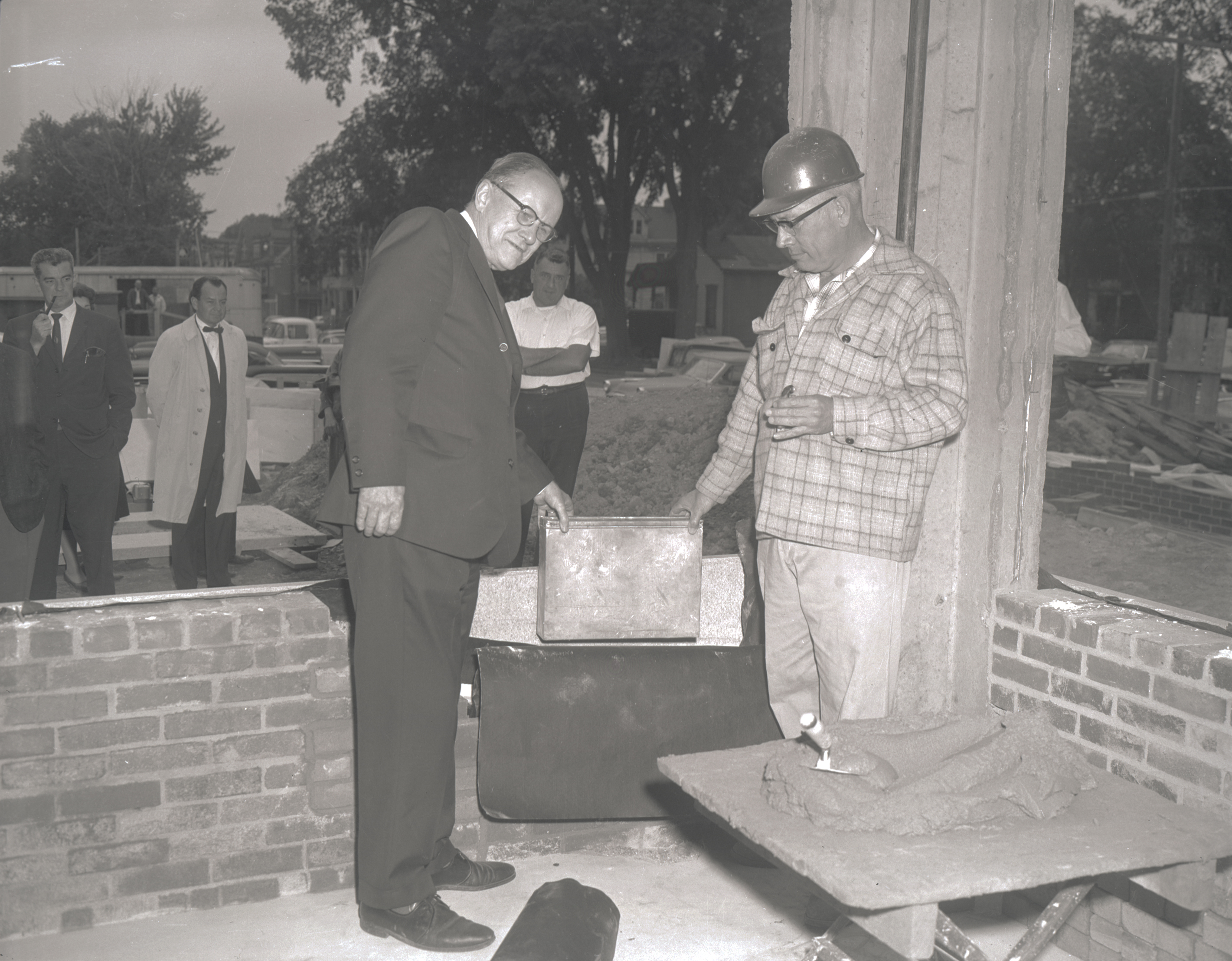 Upstate President Carlyle Jacobsen, PhD (1902-1974) and an unidentified man place a time capsule in the cornerstone of Upstate‘s downtown campus hospital, 1963.