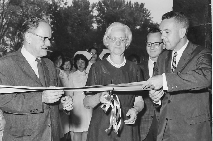 Estella Nolta, the first patient at Upstate University Hospital, downtown, cuts the ribbon on July 20, 1964. She is flanked by Upstate President Carlyle Jake Jacobsen PhD on the left and James Abbott, vice president for hospital affairs, on the right.