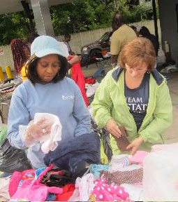 Upstate employees Joyce Freeman and Colleen McManus sort donated clothes to give away at the barbeque.