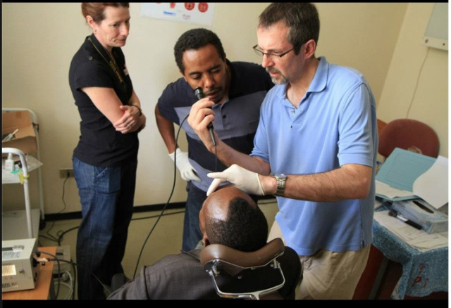 Using a flexible scope, Rick Kelley, MD, examines a patient's nasopharynx and voice box with Muluken Bekelle, MD, the first ear, nose and throat doctor Kelley trained in Ethiopia, equipping him with clinical and operating room instruments.