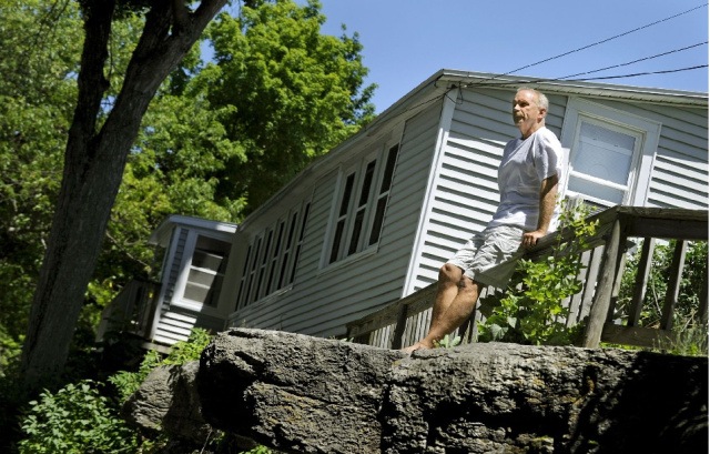 Edward L. St. George, a seasonal resident in Cape Vincent, looks out toward the St. Lawrence River near the spot from which he fell last summer and broke his neck. Photo by Amanda Morrison, Watertown Times