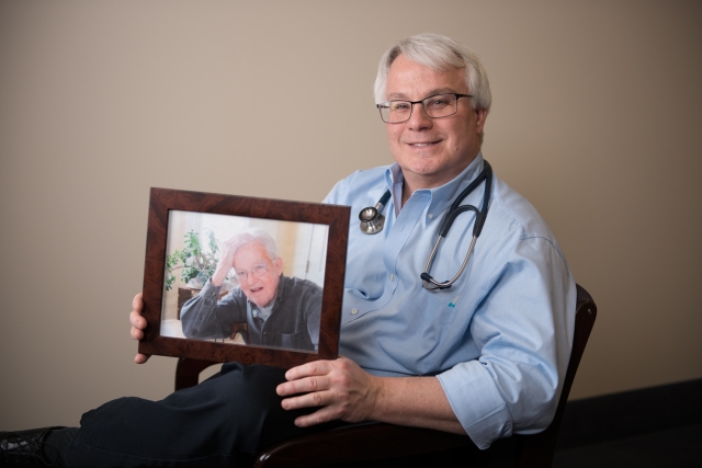 Timothy Creamer, MD, holds a photo of his father, George. Creamer is division chief of hospital medicine at Upstate University Hospital, Community Campus. PHOTO BY SUSAN KAHN.