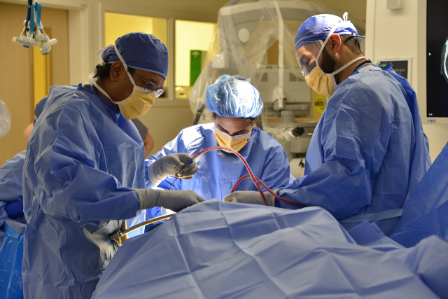 Neurosurgeon Satish Krishnamurthy, MD, left, with residents Meg Riordan, MD, and Ali Hazama, MD.